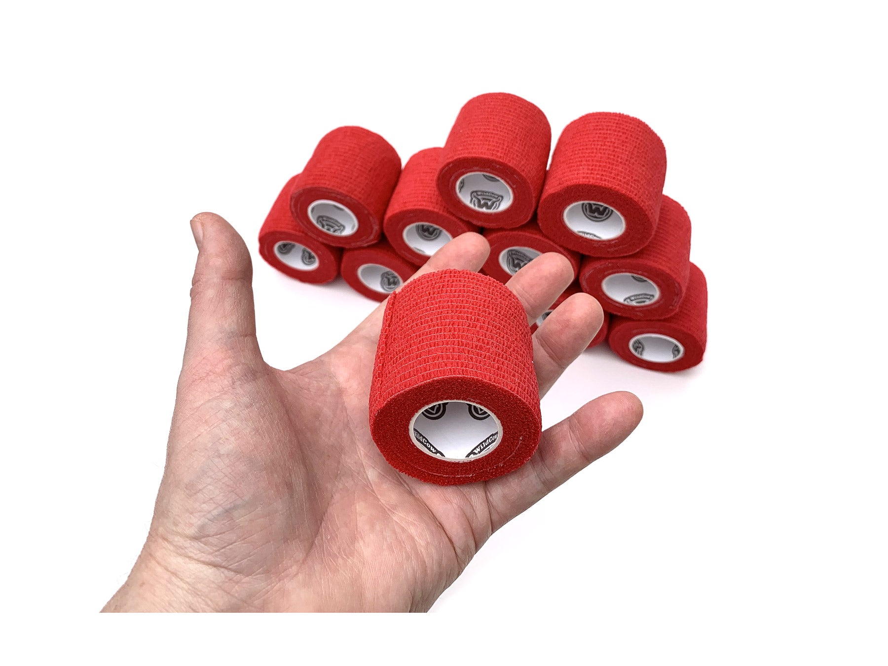 Hand Holding 1 of 12 Rolls of WildCow Red 2 Inch Vet Wrap