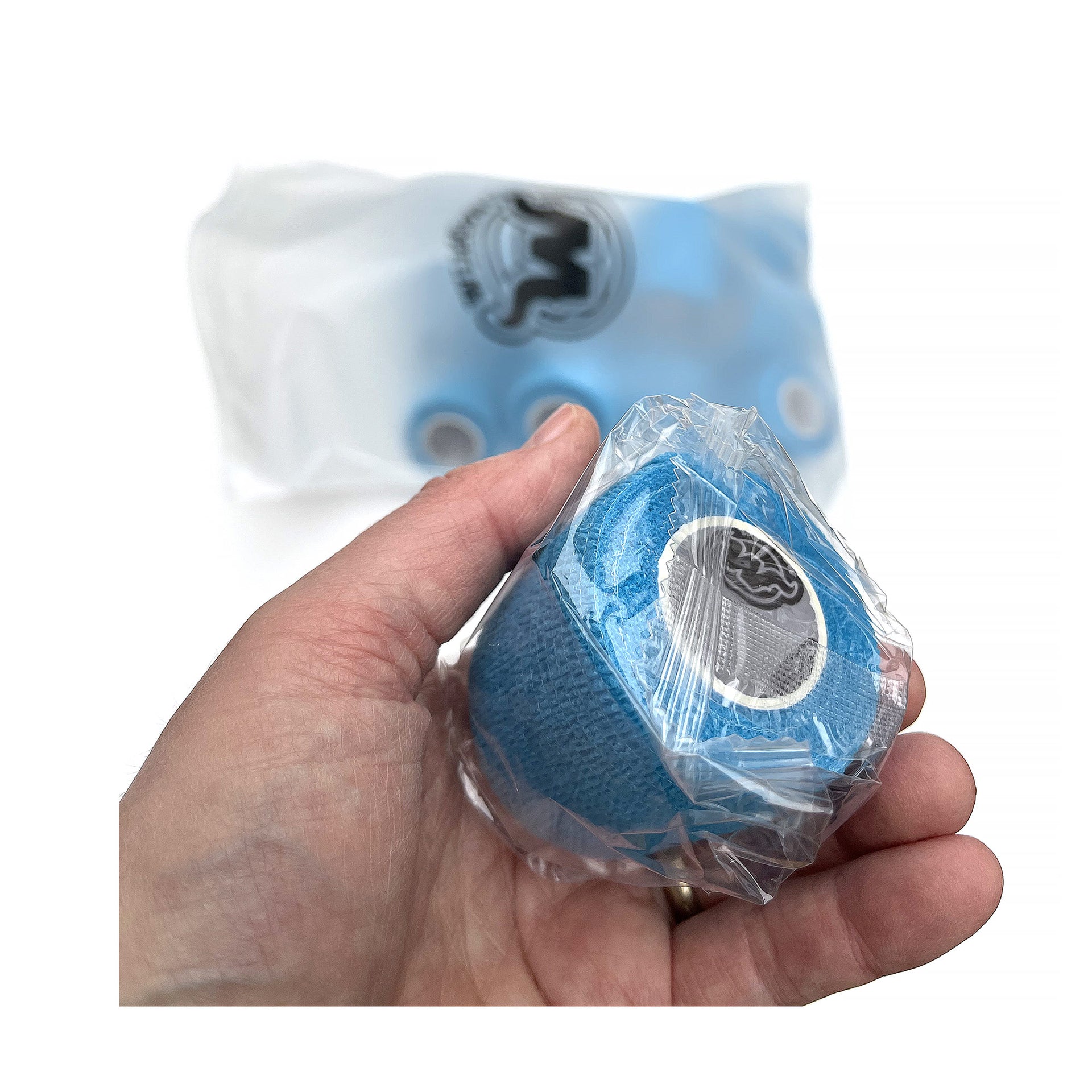 Hand Holding Plastic Wrapped Roll of WildCow 2 Inch Light Blue Vet Wrap Rolls